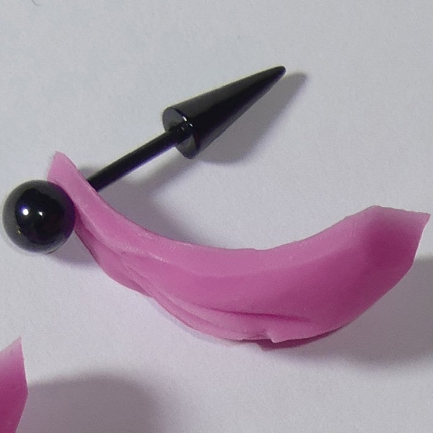 A black metal tongue piercing barbell with a pink silicone BarbieVagina, shown on a plain light background.