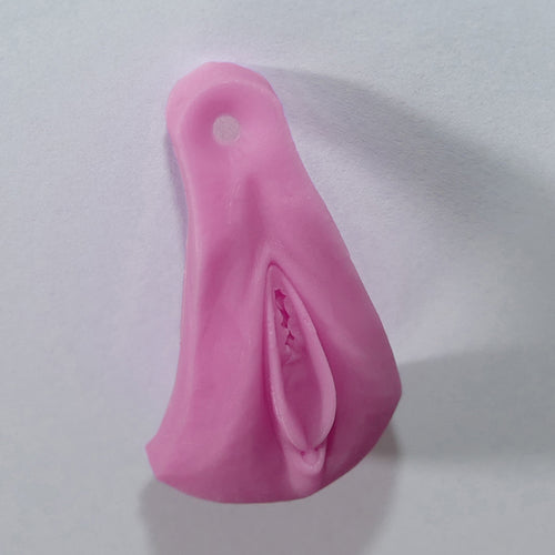 A pink silicone adult novelty product with a textured, realistic interior design, shown on a plain light gray background.