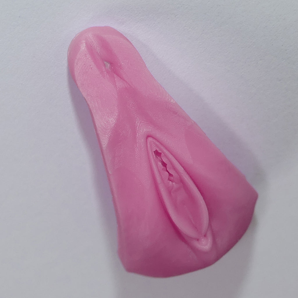 A pink silicone ass adult novelty product with a realistic textured surface, photographed on a plain light background.