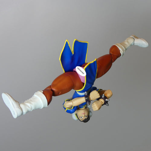 Street Fighter 6 Chun-Li action figure BarbieVagina posed upside down against a solid gray background.