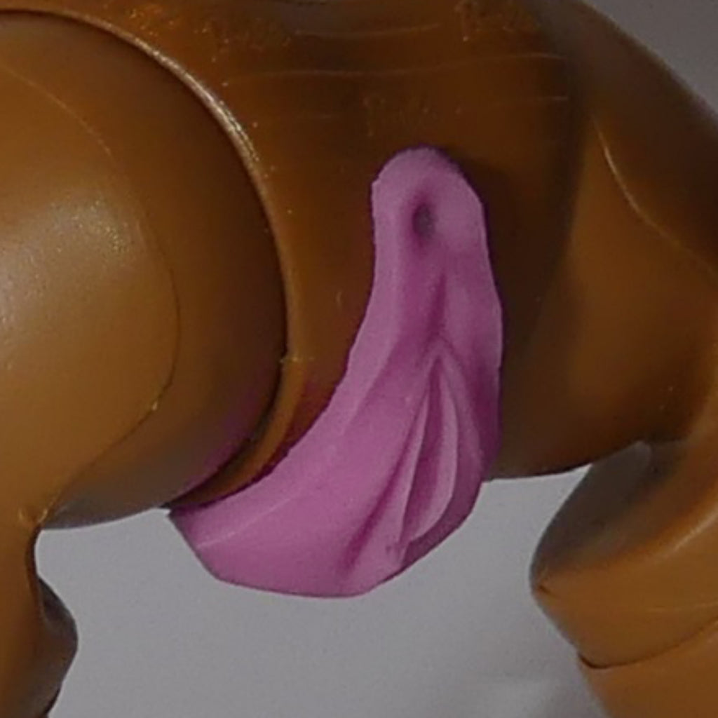 A close-up of a brown plastic toy figure showing a pink molded accessory attached near the hip area, photographed against a plain light background.